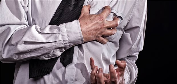 Mann greift sich krampfhaft an die Brust.