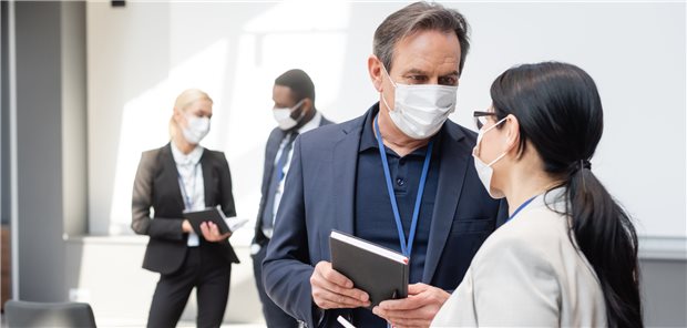 Face-to-face-Austausch mit Kollegen – aber mit Maske: Das ist nur bei Vor-Ort-Teilnahme einer Tagung möglich.