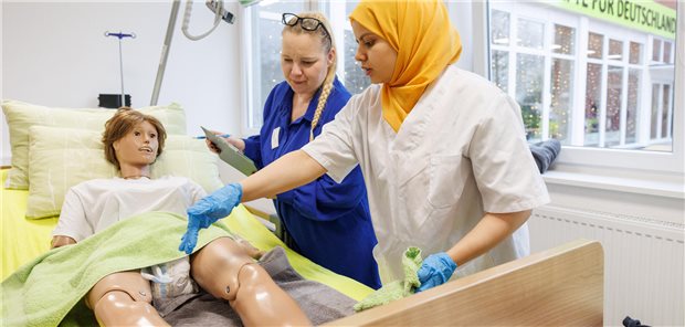 Ausländische Pflegeperson übt an einer Puppe