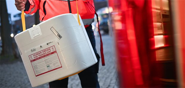 Ein Mann trägt ein menschliches Organ in der Transportbox.