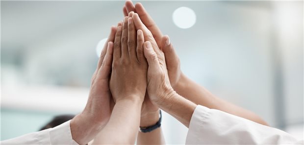 Mehrere Handflächen klatschen aneinander.