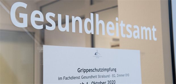 Ein Hinweis auf die Grippeschutzimpfung hängt an der Eingangstür eines Gesundheitsamts.