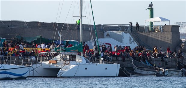 Kanaren fürchten mehr COVID-Infektionen durch Flüchtlinge Flüchtlinge stehen an der Mole der Hafenstadt Arguineguín im Südwesten von Gran Canaria. Immer mehr Migranten wagen die Überfahrt aus Afrika.