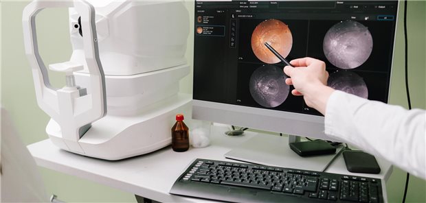 Ein Augenarzt erläutert die Netzhautbilder eines Patienten auf dem Bildschirm und zur Erklärung der Erkrankung und ihrer Symptome.