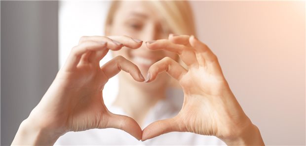 Eine Frau formt mit ihren Fingern ein Herz.