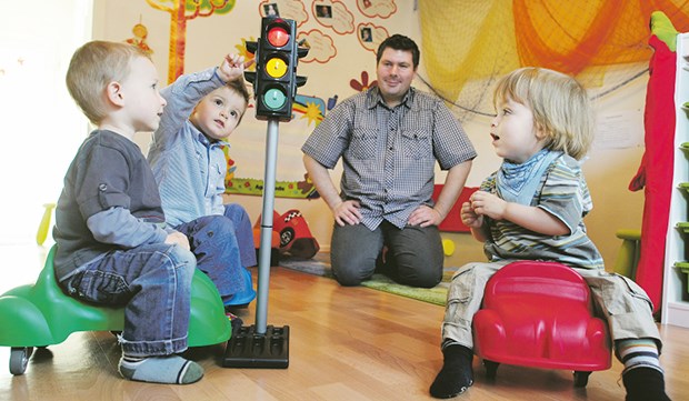 Ein Tagesvater für Fritz, Max und Dominik Fritz, Dominik und Max (v.l.) fahren auf Kinderautos, Tagesvater Ronald Lennartz passt auf.
