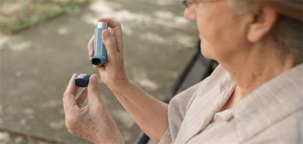 Frau hält Asthmaspray in der Hand