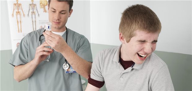 Ein Jugendlicher verzieht das Gesicht, bevor er eine Impfung bekommt.