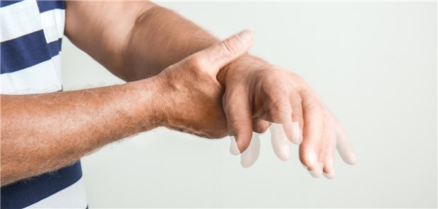 Ein Mann hält mit seiner rechten Hand die zittrige linke.