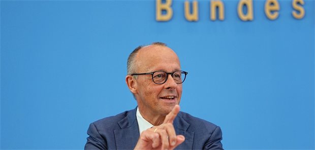 Bundeskanzler Friedrich Merz sitzt im Saal der Bundespressekonferenz und gestikuliert.