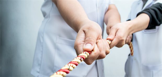 vier Hände ziehen an einem Strang