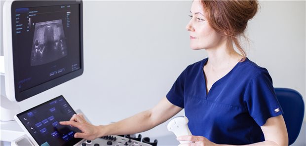 Ärztin bedient Ultraschallgerät.