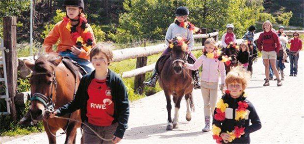 Fröhliche Therapie mit Langzeitwirkung Geschmückt mit schwarz-rot-goldenen WM-Fanartikeln zieht die bunte Truppe zu einem Ausritt in den Wald.