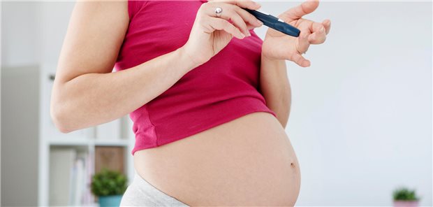 Schwangere Frau misst ihren Blutzuckerwert.