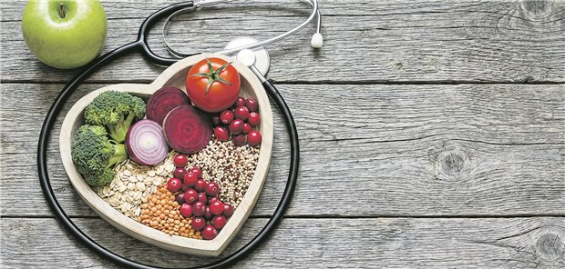 Eine Herzform mit Lebensmitteln wie Tomaten, Brockoli auf einem Tisch.