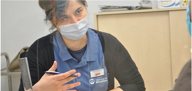 Gesundheitskiosk: Impfung braucht Vertrauen Gesundheitsberaterin Cagla Kurtca spricht mit einem Besucher im Gesundheitskiosk über das Impfen.
