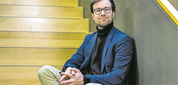 Der Arzt und Bundestagsabgeordnete von Bündnis90/ Die Grünen, Johannes Wagner, sitzt auf einer Treppe in einem  Bürogebäude des Bundestags.