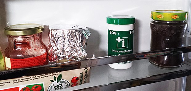 Notfalldose – Flaschenpost zur Rettung Gewöhnungsbedürftiges Bild: Eine Notfalldose neben Marmelade und Tomatenmark im Kühlschrank.