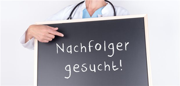 Arzt mit einem Schild mit der Aufschrift &quot;Nachfolger gesucht!&quot;