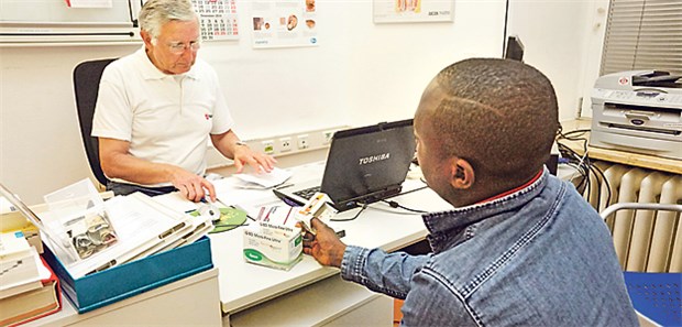 Krasse Versorgungsdefizite bei Flüchtlingen Glück gehabt: Flüchtling aus Ghana, versorgt von Detlev Niebuhr (l) von der Malteser-Migranten-Medizin.