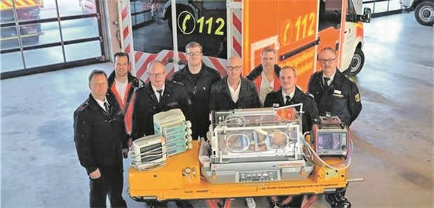 HighTech-Taxi für allerjüngste intensivmedizinische Patienten Gruppenbild mit Inkubator vor dem neuen Baby-Intensiv-Transportwagen der Bielefelder Feuerwehr: In die Sonderkonstruktion floss die Expertise von Feuerwehrleuten und Medizinern ein – darunter von Dr. Stefan Heinzel (4. v.r.), Ärztlicher Leiter der Neonatologie im Perinatalzentrum am Evangelischen Klinikum Bethel.