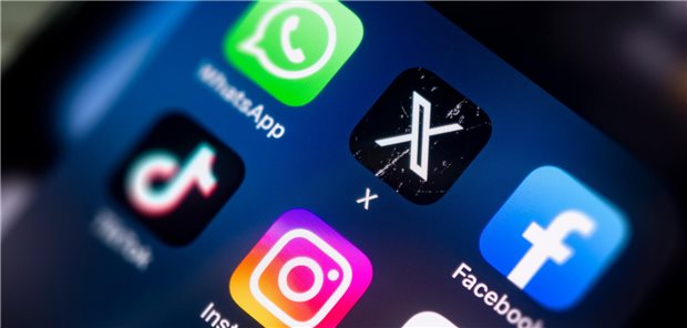 Handy-Display in Nahaufnahme mit Fokus auf die Symbole von WhatsApp, X, Facebook, TikTok und Instragram.