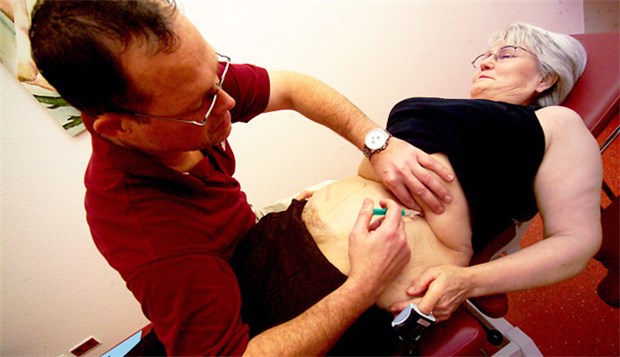 Am Facharzt für Schmerzmedizin führt kein Weg vorbei Häufiges Bild in der Schmerztherapie: Der Arzt gibt der Patientin eine Injektion.