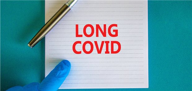 Bund stockt Förderung zu Long-COVID auf Hand im Handschuh zeigt auf „Long COVID“ auf einem Block: Die Bundesregierung fördert die Forschung zum Long-COVID-Syndrom.