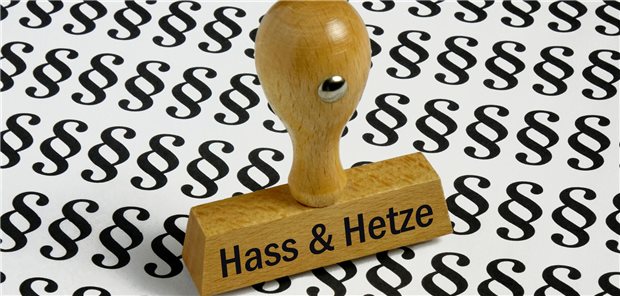 Stempel mit der Aufschrift "Hass & Hetze" auf Paragrafen