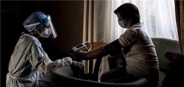 Mit der Coronakrise umgehen – eine Frage der inneren Freiheit Hausbesuch in Zeiten der Pandemie: Eine Ärztin in Schutzkleidung misst einer mit SARS-CoV-2 infizierten Patientin den Blutdruck. Nur wer sich in der Krise selbst schützt, bleibt stark genug, um auch anderen beistehen zu können.