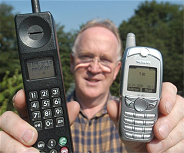 1990 - Mehr Farbe und Kommunikation Heinz Sänger, Inhaber des "Handy-Museums", mit einem der ersten GSM-Mobilfunkgeräte (Motorola International 3200 von 1994, links) und einem Handy aus dem Jahr 2002 (Siemens, rechts).