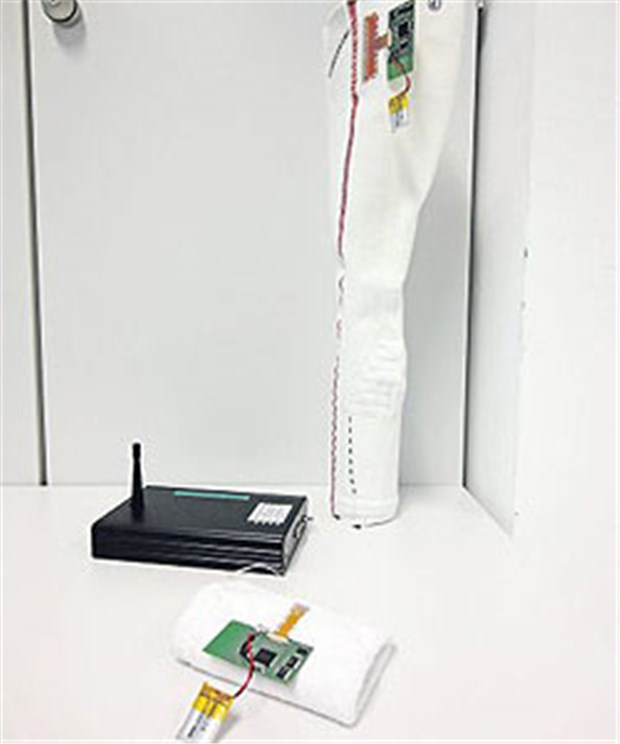 "Intelligenter" Strumpf gegen Diabetischen Fuß Hinten der sensorische Strumpf, in der Mitte (schwarzes Gehäuse) liegt die Basisstation, vorne die Meldeeinheit.