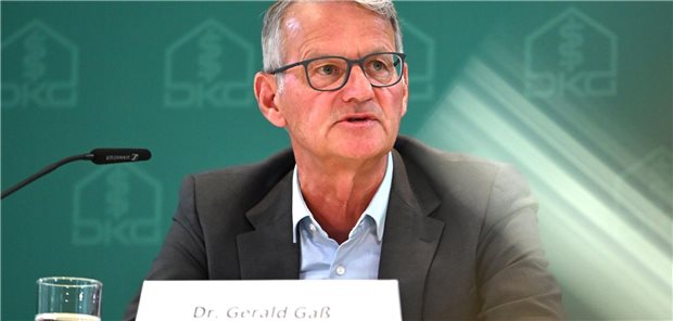 Ein Mann, Dr. Gerald Gaß, Vorstandsvorsitzender der Deutschen Krankenhausgesellschaft, sitzt vor einem Mikrofon.