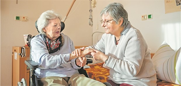 Den Gehörlosen Gehör schenken Hospizbegleiterin Doris Ehrenreich (rechts) gibt der gehörlosen Lieselotte Beck eine Handmassage.