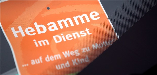 Viele Hebammen denken über Berufsaufgabe nach Im Einsatz: Eine Hebamme hat das Schild „Hebamme im Dienst“ hinter die Windschutzscheibe ihres geparkten PKW gelegt,