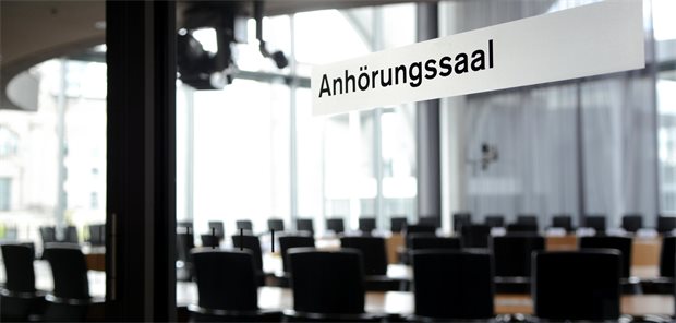 Das Foto zeigt auf einer Glastür das Schild "Anhörungssaal".