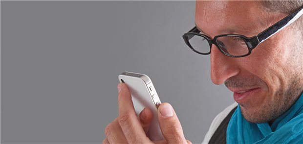 Der suchende Patient Mann schaut auf sein Smartphone.