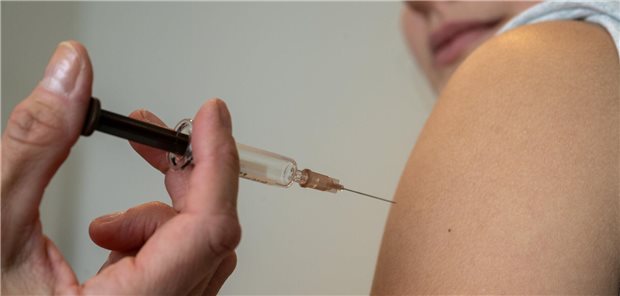 Ein Teenager wird in den Arm geimpft.
