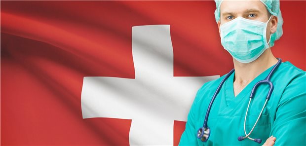 Ärzte aller Länder zieht es für den Job in die Schweiz Arzt vor Schweizer Flagge