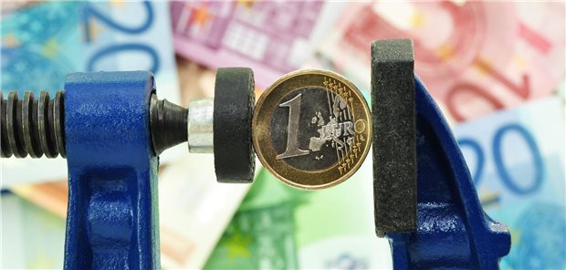 KKH erhöht zum August Zusatzbeitrag auf Rekordwert Eine Euro-Münze in einer Schraubzwinge