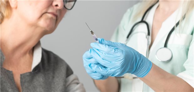 Eine Ärztin zeigt einer Patientin eine Kanüle.