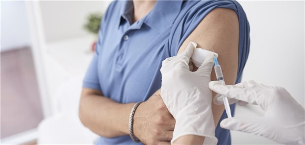 Eine Ärztin impft eine Patientin in die Schulter. 