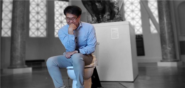 In Denkerpose auf der Toilette: Der südkoreanisch-amerikanische Forscher Seung-min Park hat den Ig-Nobelpreis 2023 in der Kategorie Public Health für die Erfindung der „Stanford-Toilette“ erhalten. Im Hintergrund ansatzweise zu sehen: eine Kopie von Auguste Rodins weltberühmter Plastik „Der Denker“.