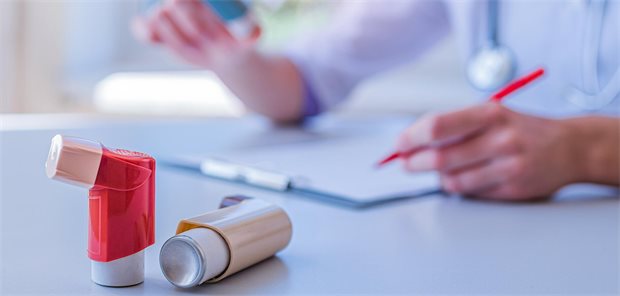 Ein Arzt stellt während einer ärztlichen Konsultation und Untersuchung ein Rezept für einen Asthma-Inhalator aus.