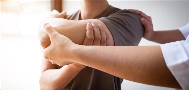 Arzt hält Arm eines Patienten.