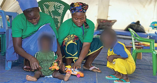 Die schlimmen Spätfolgen von Ebola In Gueckedou, Guinea, spielen zwei Ebola-überlebende Frauen mit Kindern, die in einer Kinderkrippe auf eine mögliche Ebola-Infektion beobachtet werden.