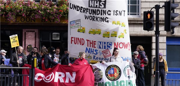 In Leeds halten Menschen im Oktober während einer Kundgebung ein Banner mit der Aufschrift „Unterfinanzierung funktioniert nicht – finanziert den NHS (National Health Service) jetzt“. Die Auslöser der Demonstration waren steigende Energierechnungen und die Krise der Lebensunterhaltungskosten.