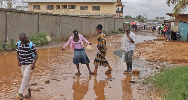 Erst der Regen, dann die Cholera In Liberias Hauptstadt Monrovia laufen Bewohner über eine überflutete Straße. Die Regenzeit fiel 2012 stark aus.