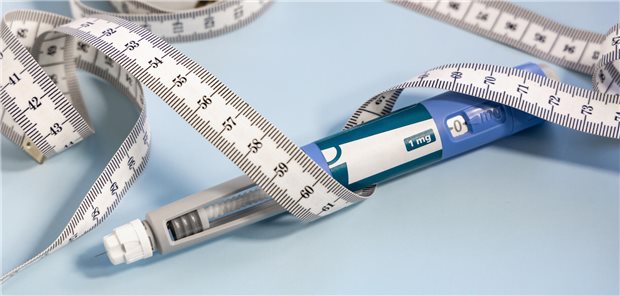 Spritzenstift mit „nährstoffstimulierenden Hormonen“ und ein Maßband auf blauem Hintergrund.