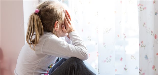 Diskussionsrunde zu Kinder und Corona: Geld genügend vorhanden, Helfer nicht Ein kleines Mädchen sitzt während der Corona-Pandemie einsam in Ihrem Zimmer vor der Balkontür
